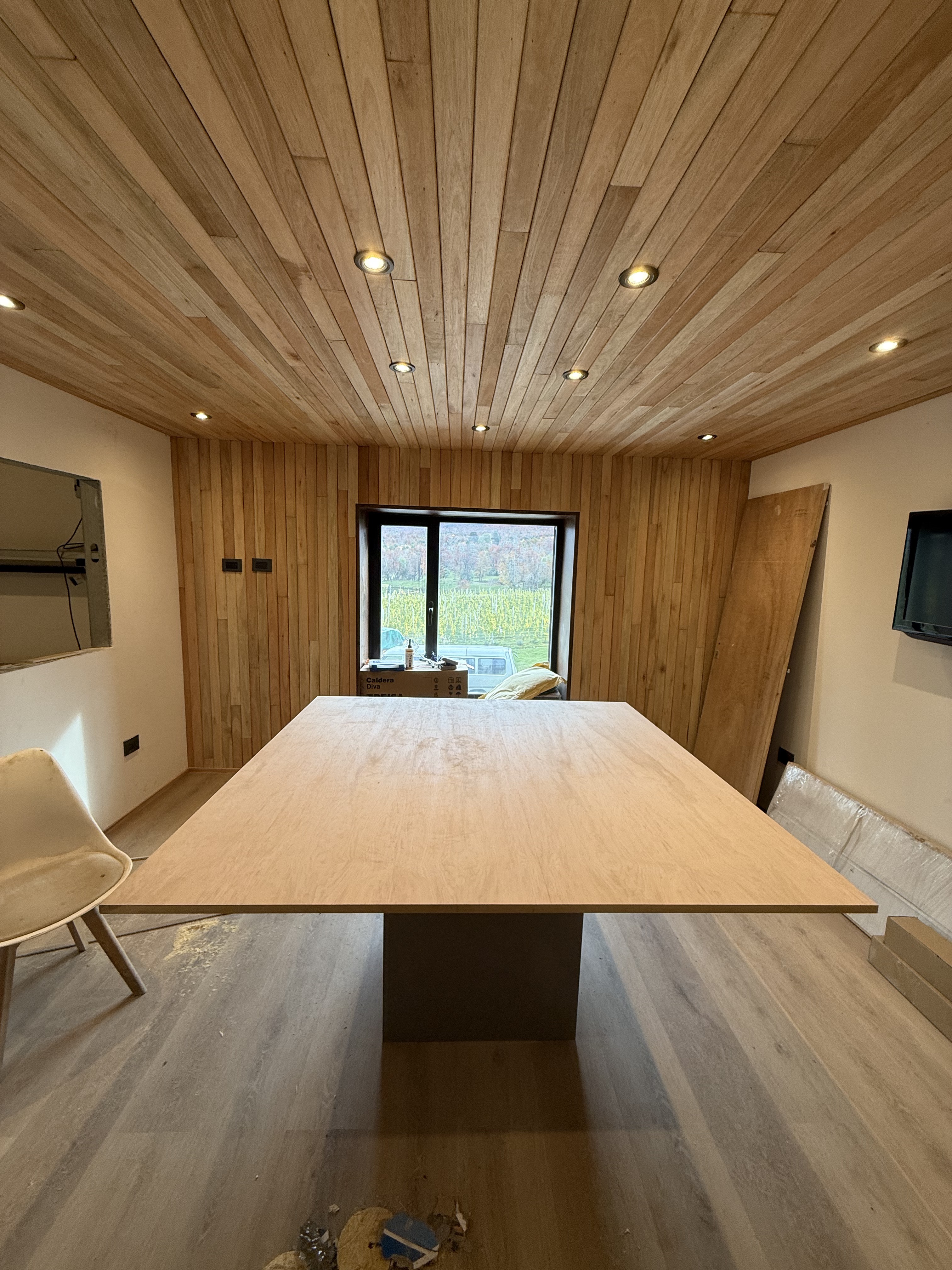 Comedor con cielorraso de madera y ventanal panorámico — obra SURFACE